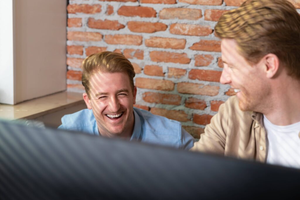 Koen en Wessel lachen om iets op hun scherm -Hey Marketing